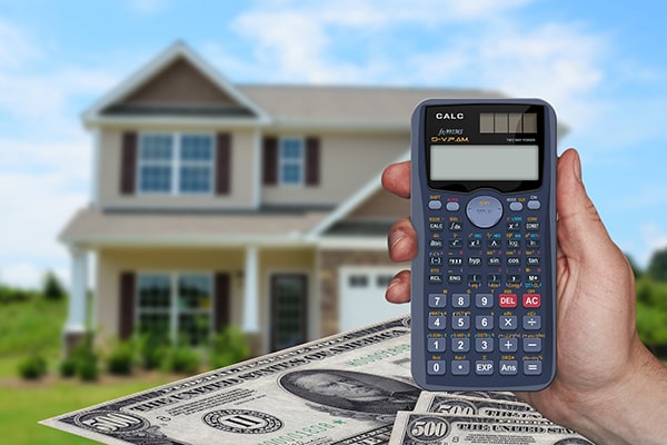 House with person holding calculator