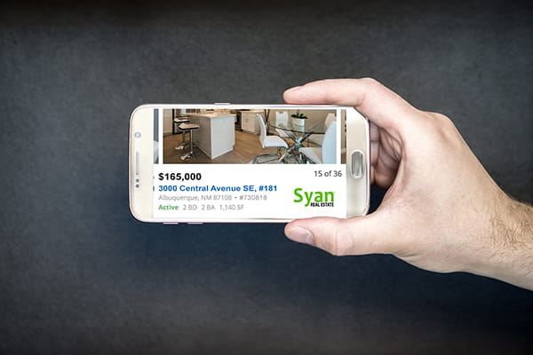 Hand holding phone with listing alert on screen